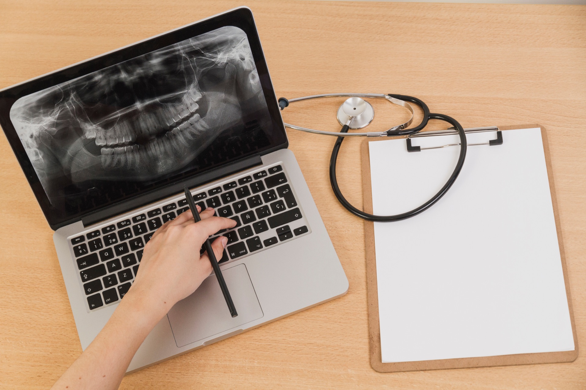 Dental radiography on laptop with stethoscope and clipboard on desk
