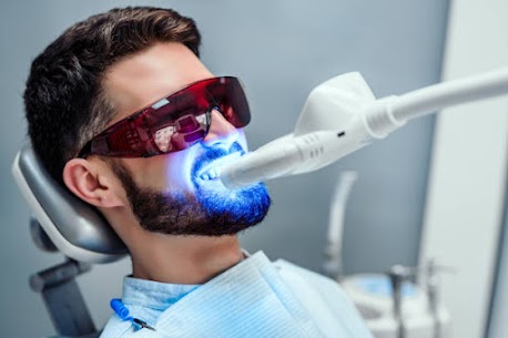 Patient undergoing professional blue-light teeth whitening treatment at Enbite Dental Studio